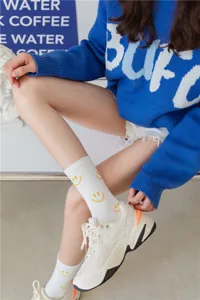 Chaussettes mi-mollet en coton blanc pour femme avec visage souriant jaune, usage quotidien.