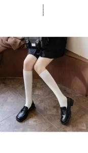 Vue détaillée de chaussettes blanches élégantes associées à des mocassins noirs style JK.
