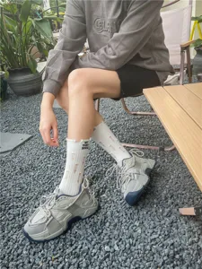 Calze bianche da donna alla moda con dettagli strappati e stampa a lettere urban chic.