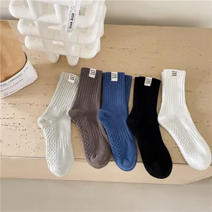 Chaussettes mi-hautes classiques en coton pour hommes et femmes, avec texture côtelée élégante.