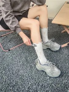 Calze da donna alla moda con fori e effetto vissuto abbinate a sneaker chunky grigie.