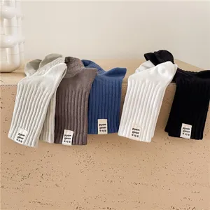 Chaussettes mi-hautes en coton épais rayé pour hommes aux couleurs unies avec étiquette.
