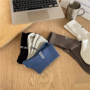 Detailed view of ribbed casual mid-tube socks in assorted colors with small label design.