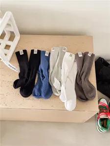 Vue détaillée de chaussettes mi-hautes en coton côtelé avec étiquette en tissu multicolore.