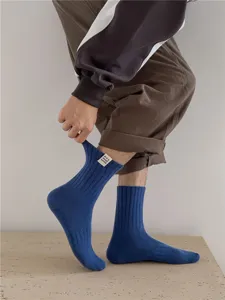 Gros plan détail de chaussettes homme bleu foncé côtelées avec un petit design étiquette style.