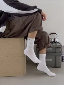Détail de chaussettes mi-hautes en coton pour homme avec design côtelé et étiquette tissée.