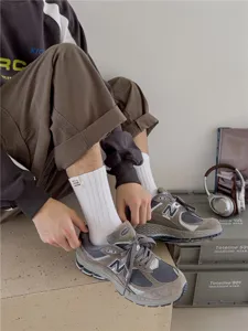 Vue détaillée des chaussettes en coton pour hommes avec petit patch, associées à des baskets.