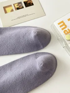 Chaussettes hautes côtelées violettes douces pour femmes, mode hivernale élégante.