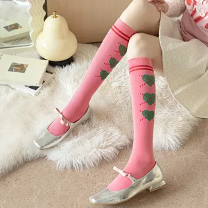 Chaussettes hautes roses style collège français avec coeurs verts et design rétro mignon.