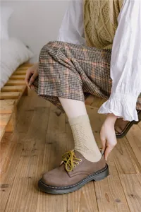 Close-up view of cozy cable-knit wool blend socks paired with retro shoes, autumn style.