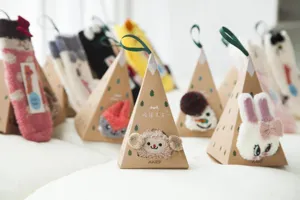 Detailansicht von süßen bestickten dicken Korallenfleece Bodensocken in Pyramiden Geschenkboxen.
