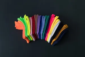 Nahaufnahme bunter Rippstrick-Stulpensocken, sauber angeordnet in kräftigen Neon- und Bonbontönen.