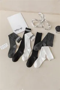 Klassische gestreifte Kniestrümpfe in Schwarz, Weiß und Grau mit Rippstrick-Detailansicht.