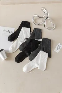 Stylische schwarz weiss grau gestreifte Kniestruempfe fuer Damen, modische lange Freizeitsocken.