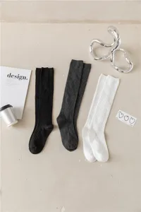 Detailaufnahme von einfarbigen schwarzen, grauen und weißen Rippstrick Kniestrümpfen.