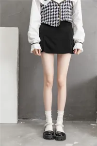 Vue rapprochée de chaussettes blanches japonaises associées à une mini-jupe noire et des chaussures.