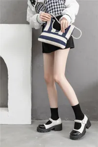 Chaussettes noires élégantes associées à de charmantes chaussures Mary Jane et un sac en toile.