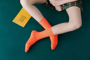 Detailansicht von leuchtend orange gerippten Baumwollsocken auf dunklem Hintergrund.
