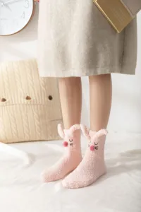 Detail shot of cute fluffy rabbit ear plush socks, thick warm coral fleece home sleep socks.