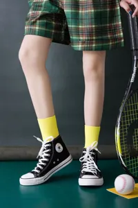 Fluoreszierende gelbe Damen-Mittelsocken aus Baumwolle mit stylischen Turnschuhen.
