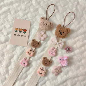 Close-up of cute bear and bunny plush patches on hair accessory organizer wall strap