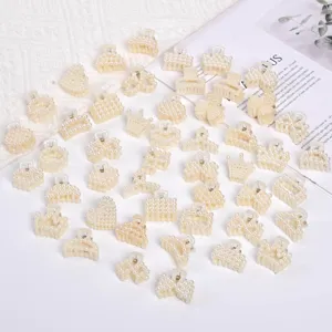 Detailed view of various small cream pearl hair claw clips on white background