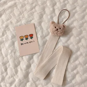 Detailed view of cute plush bear hair clip organizer strap with herringbone ribbon