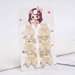 Detailed macro view of small pearl flower hair claw clips set on a decorative display card