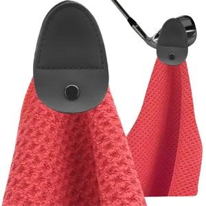 Detail view of red microfiber golf towel with black magnetic leather clip attachment