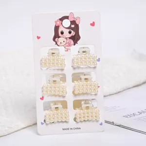 Set of six small elegant faux pearl hair clips presented on a white display card