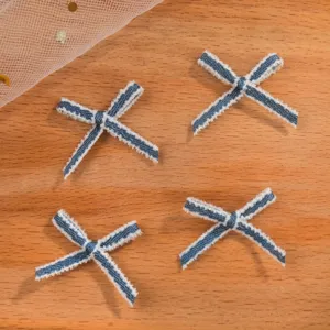 Dettaglio di quattro piccoli fiocchi in nastro a righe bianche e blu per abiti