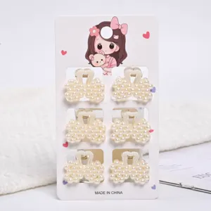 Close-up of 6 small pearl hair claw clips set presented on a cute cartoon display card