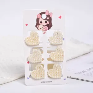 Set of six mini heart-shaped pearl hair clips for women on a white display card