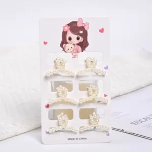 Close-up detail view of six small pearl hair claw clips on a cute decorative card.