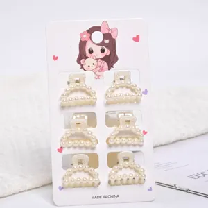 Close-up detail of 6 mini pearl hair claws mounted on a cute cartoon display card