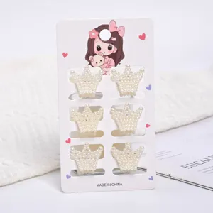 Set of six delicate mini crown-shaped pearl hair claw clips on decorative card packaging.