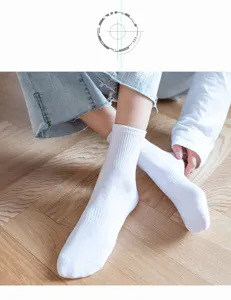 Close up view of classic solid white mid calf socks featuring comfortable ribbed cuff design.