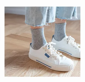 Comfortable grey mid-calf knit socks paired with classic white casual shoes for daily wear.