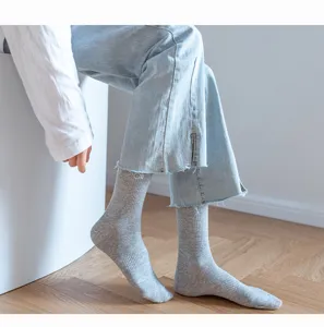 Detailed view of casual grey ribbed mid tube socks worn by model indoors, comfy daily wear.