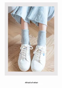 Grey ribbed mid-tube socks paired with white canvas shoes and denim, casual and trendy daily wear.