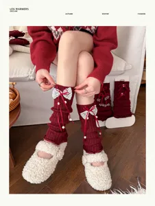 Rote gestrickte Beinwärmer mit weißen Spitzen Schleifen und Perlen für süße Lolita Looks.