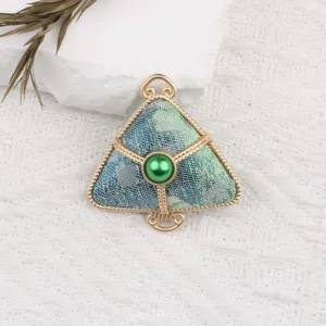 Detail view of Chinese traditional style zongzi pendant, blue brocade with gold frame and green bead.