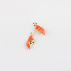 Gros plan de mini pendentifs coquillage émaillés orange, détails d'accessoires de bijoux.