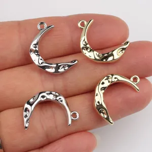 Detailopname van onregelmatige maan metalen hangers, DIY sieradenbedels in goud en zilver.