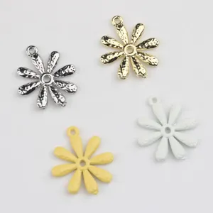 Detailopname van metalen margriet-bedels in verschillende afwerkingen voor DIY sieraden maken.