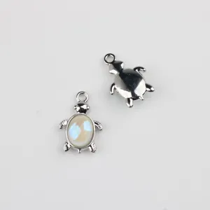 Silver turtle charm detail showing front with cabochon and plain back, DIY jewelry part