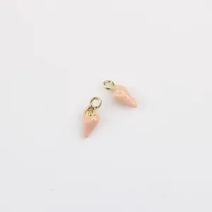 Gros plan de mini breloques coquillage émaillé rose, accessoires de bijoux DIY en métal doré.