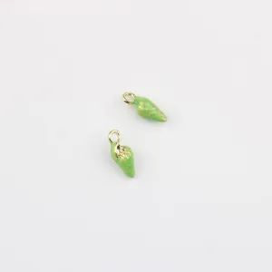 Gros plan détail de mini breloques pendentifs coquillage émail vert en alliage pour bijoux DIY.