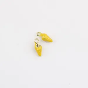 Gros plan sur le petit pendentif coquillage jaune, idéal pour la création de bijoux DIY.