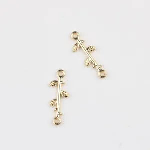 Detailed close-up view of gold branch connector charms with leaves for DIY jewelry making.